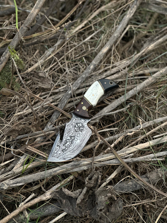 Custom handmade Damascus steel guthook skinning knife with rosewood, camel bone, and black sheet handle, paired with a leather sheath.