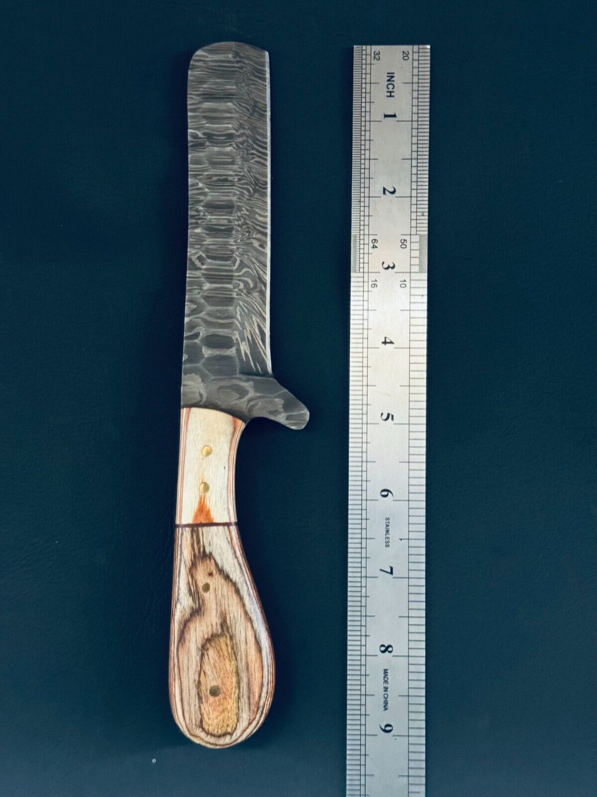 Damascus steel cowboy bull cutter knife with a 5-inch blade and leather sheath.