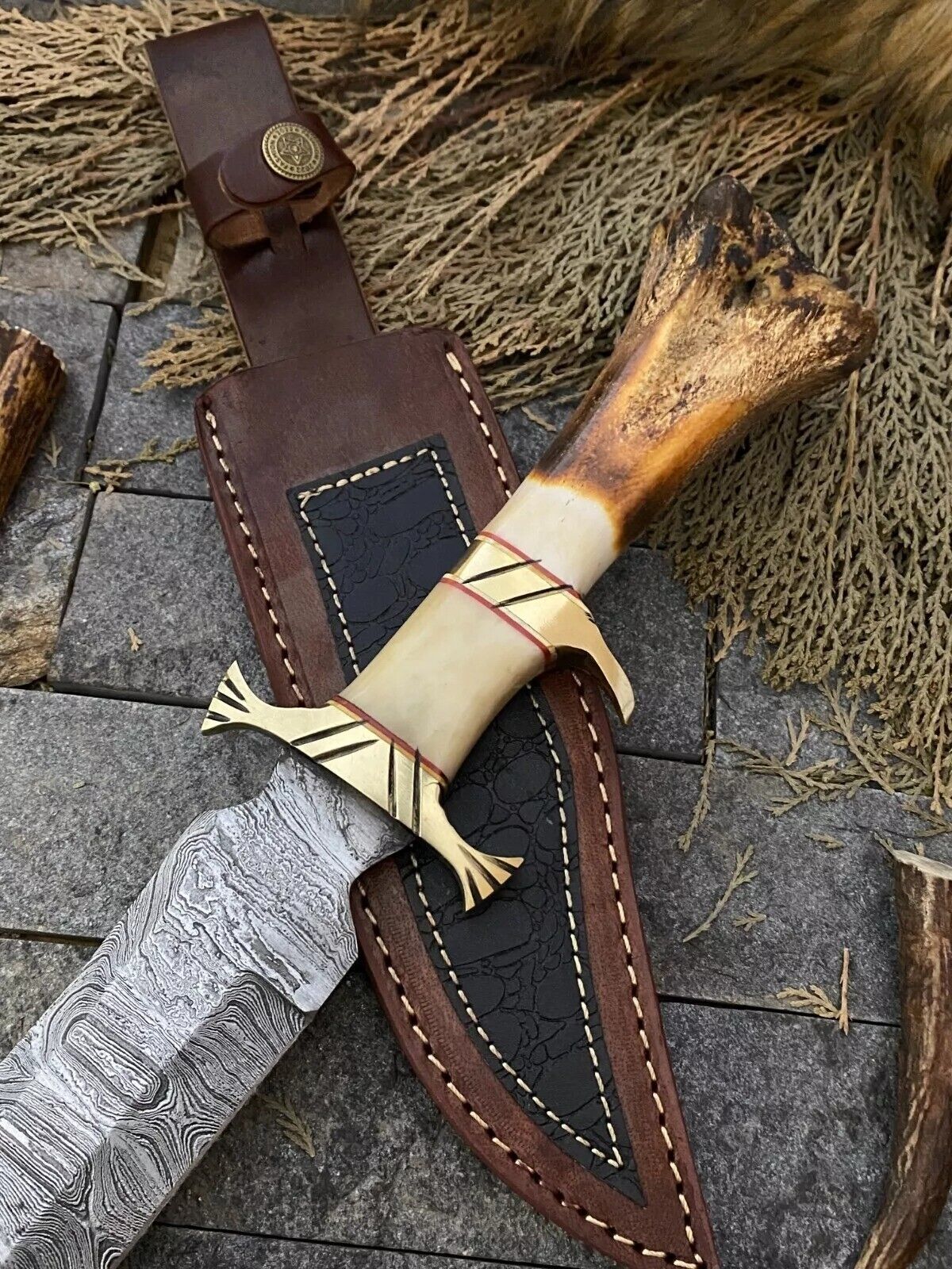 "13-inch Damascus steel Bowie knife featuring a bone handle, brass guard for added safety, and a protective leather sheath."