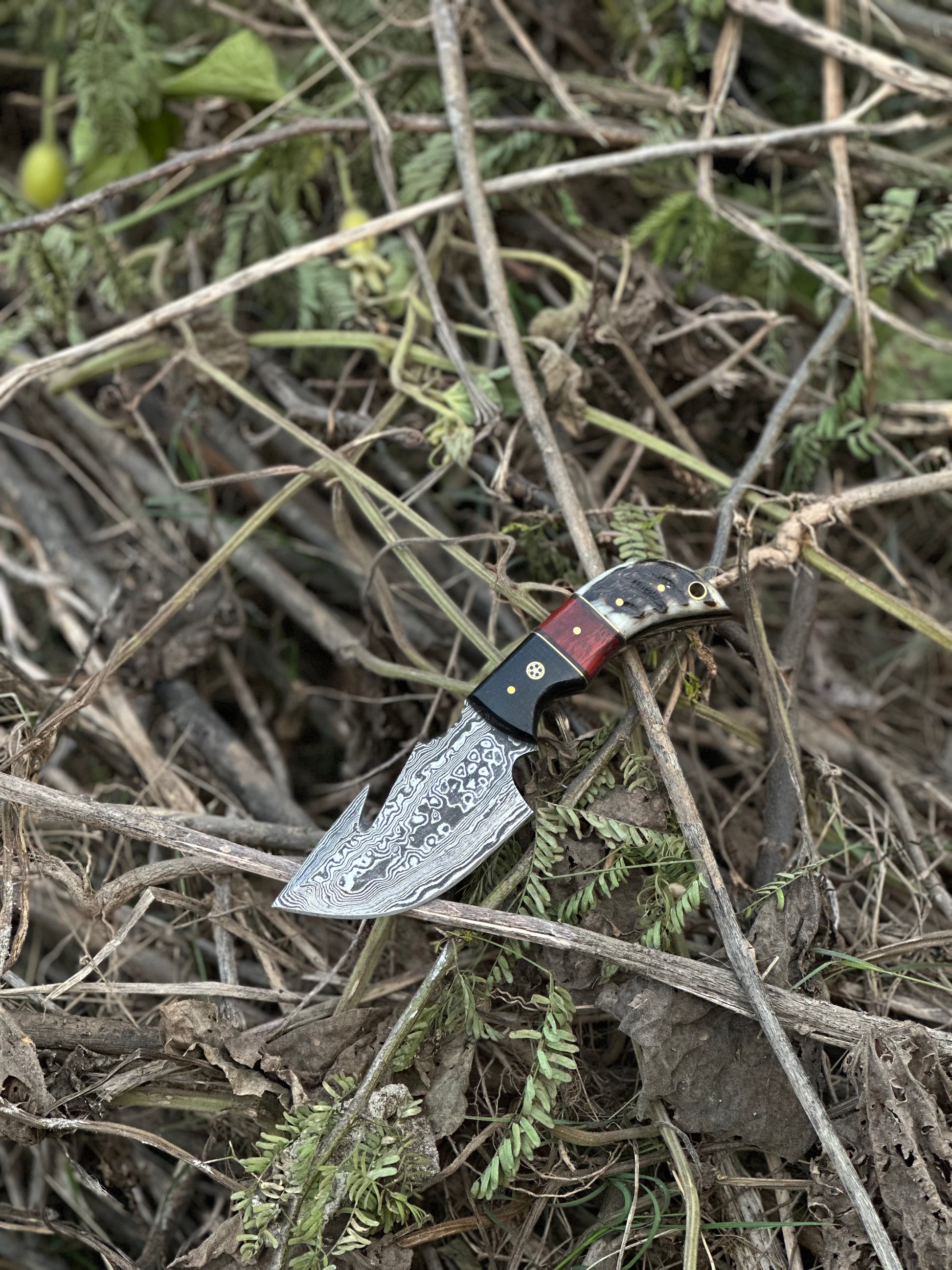 7.5” Damascus steel guthook knife with a high-quality resin handle and premium leather sheath.