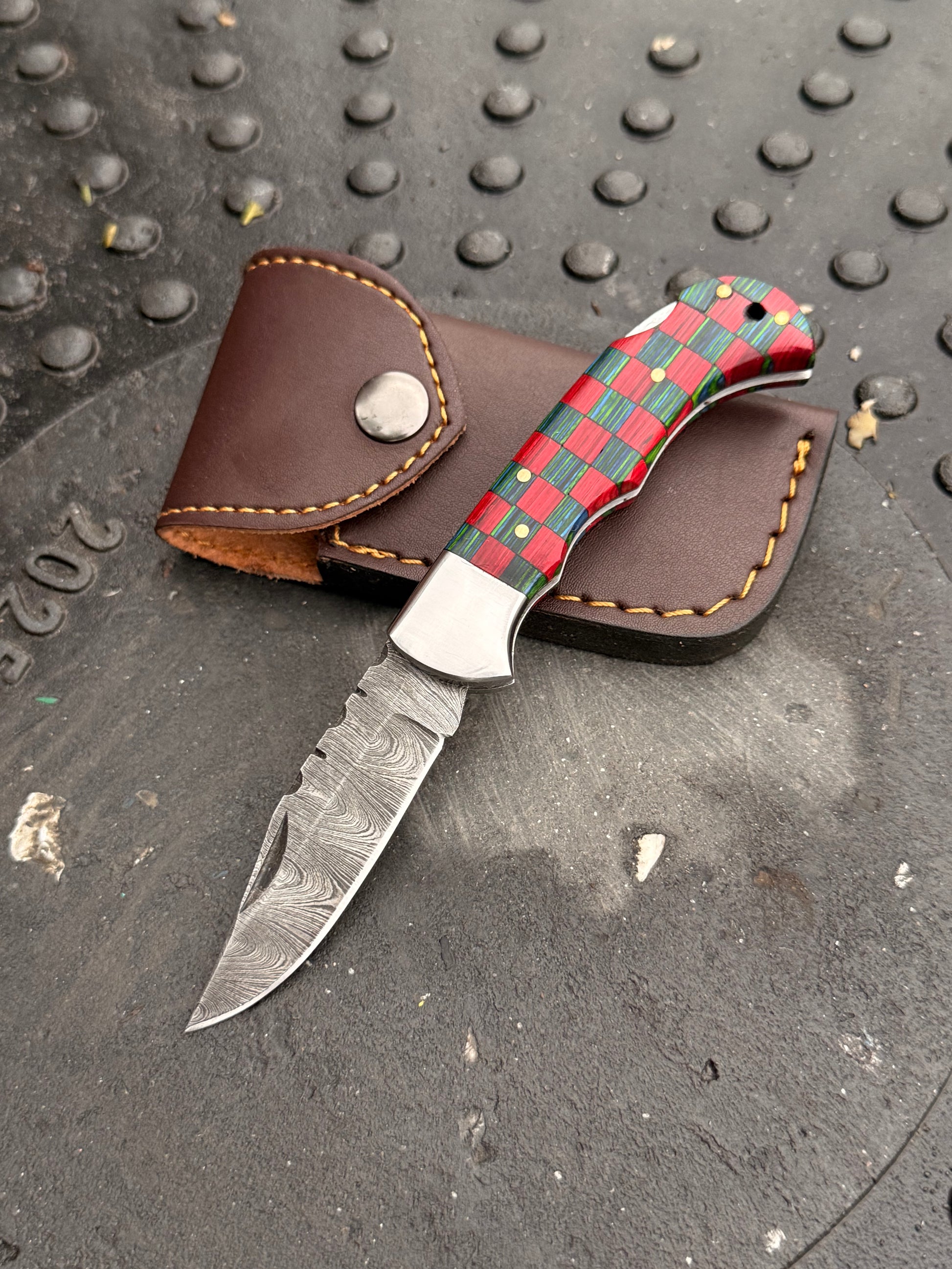 Custom folding knife with colorful handle and handmade leather sheath