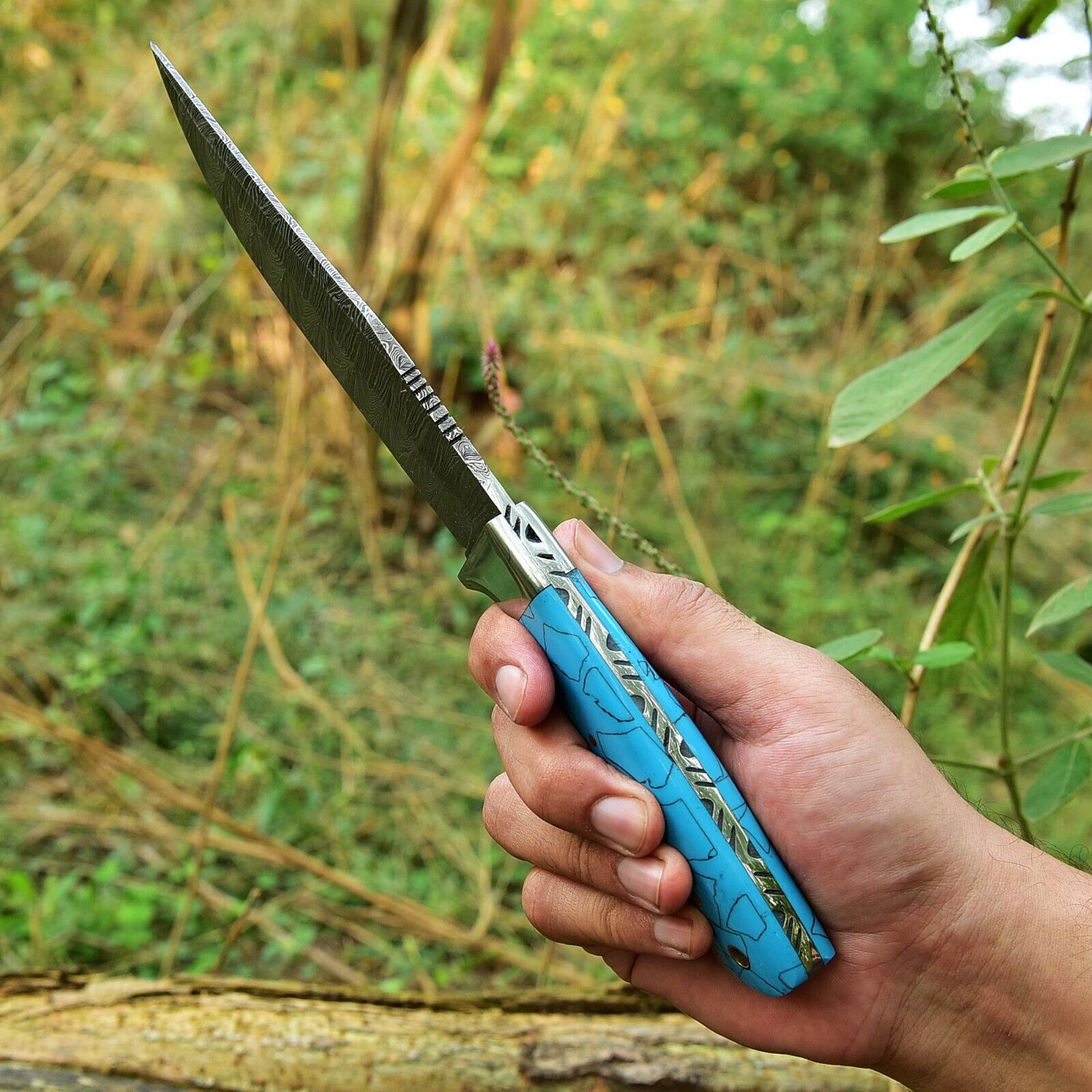 Close-up of 4.5-inch Damascus steel blade skinning knife with durable resin handle and steel bolster