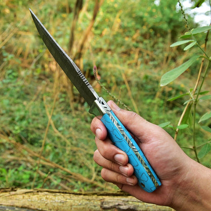 Close-up of 4.5-inch Damascus steel blade skinning knife with durable resin handle and steel bolster