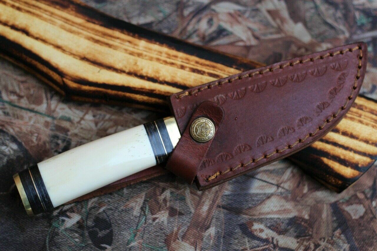 "Close-up of camping knife featuring a camel bone handle and brass guard."
