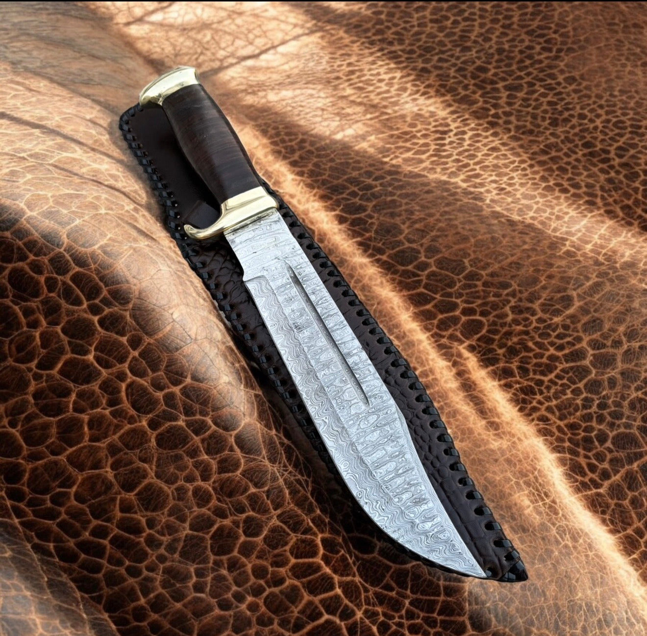Crocodile Dundee Bowie Knife with 16-inch Damascus steel blade, leather handle, brass guard, and leather sheath