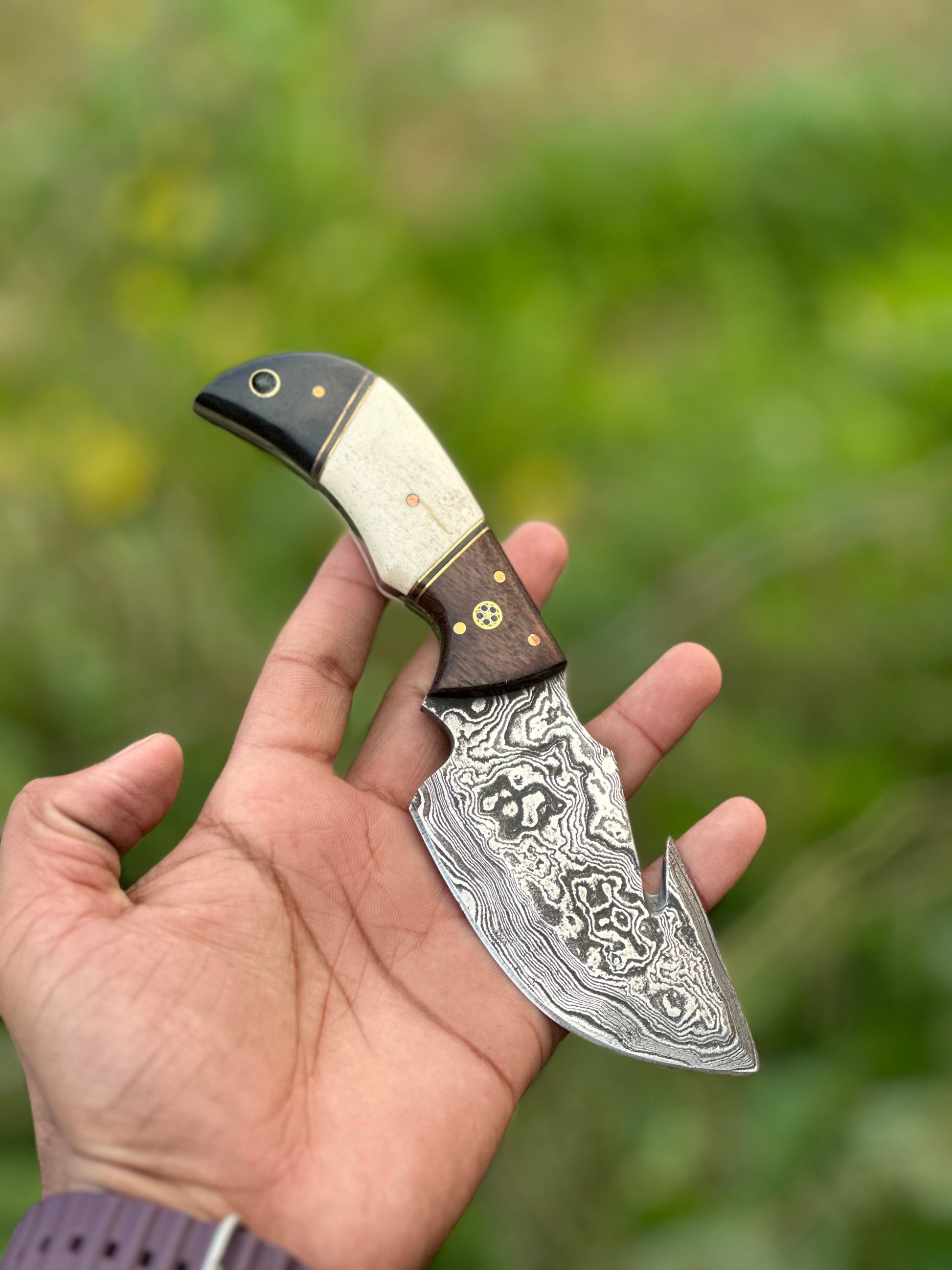 Custom Damascus guthook knife with a rosewood, camel bone, and black sheet handle, perfect gift item with leather sheath.