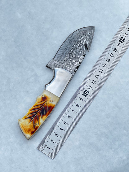 Custom Damascus pocket knife with a camel bone and rosewood handle, paired with a leather sheath