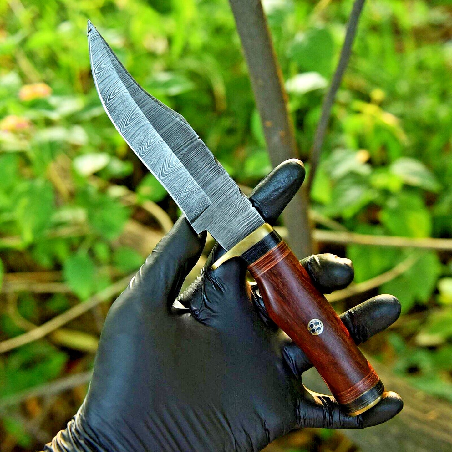 Custom Damascus steel hunting knife featuring a pakkawood handle and brass guard.