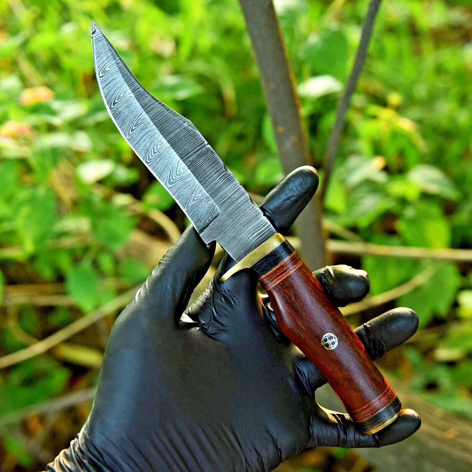 Custom Damascus steel hunting knife featuring a pakkawood handle and brass guard.