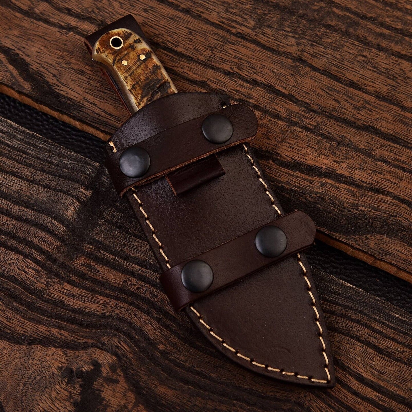 Custom Damascus steel skinning knife with sheep horn handle, featuring a 4.5-inch blade designed for precision cutting