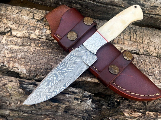 "Custom handmade Damascus bushcraft knife with a camel bone handle and steel bolster"
