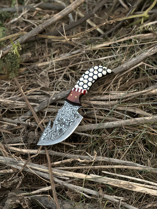 Custom handmade Damascus steel guthook skinning knife with a rosewood and resin handle, paired with a leather sheath.