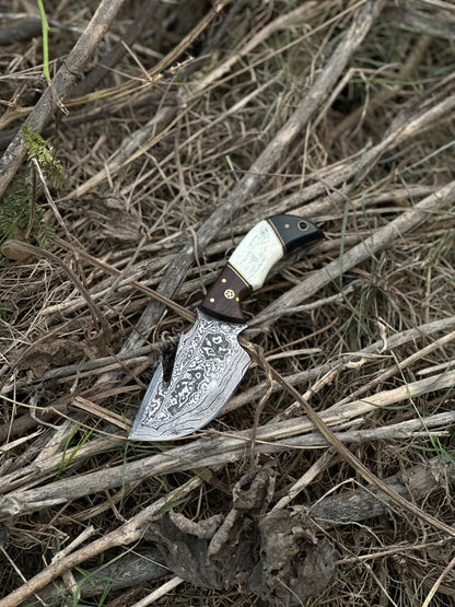 Custom handmade Damascus steel guthook skinning knife with rosewood, camel bone, and black sheet handle, paired with a leather sheath.