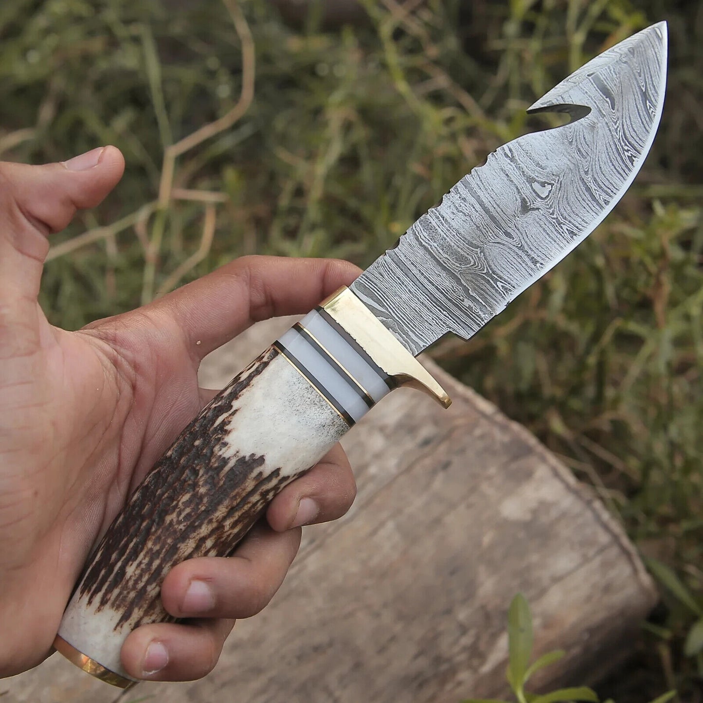 "Custom hunting knife with Damascus steel guthook blade and stag horn handle."