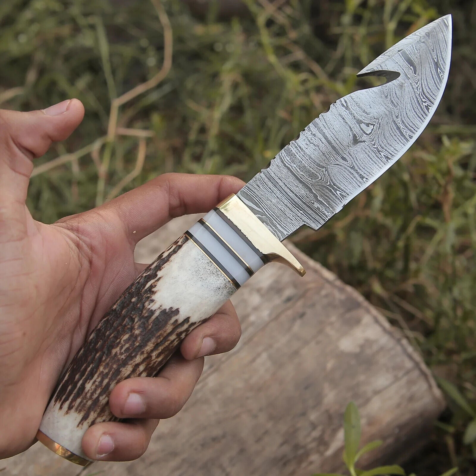 "Custom hunting knife with Damascus steel guthook blade and stag horn handle."