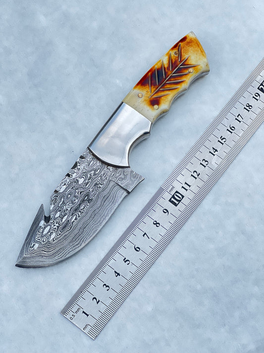 Damascus steel fixed blade knife with camel bone and rosewood handle, 7.5" with leather sheath.