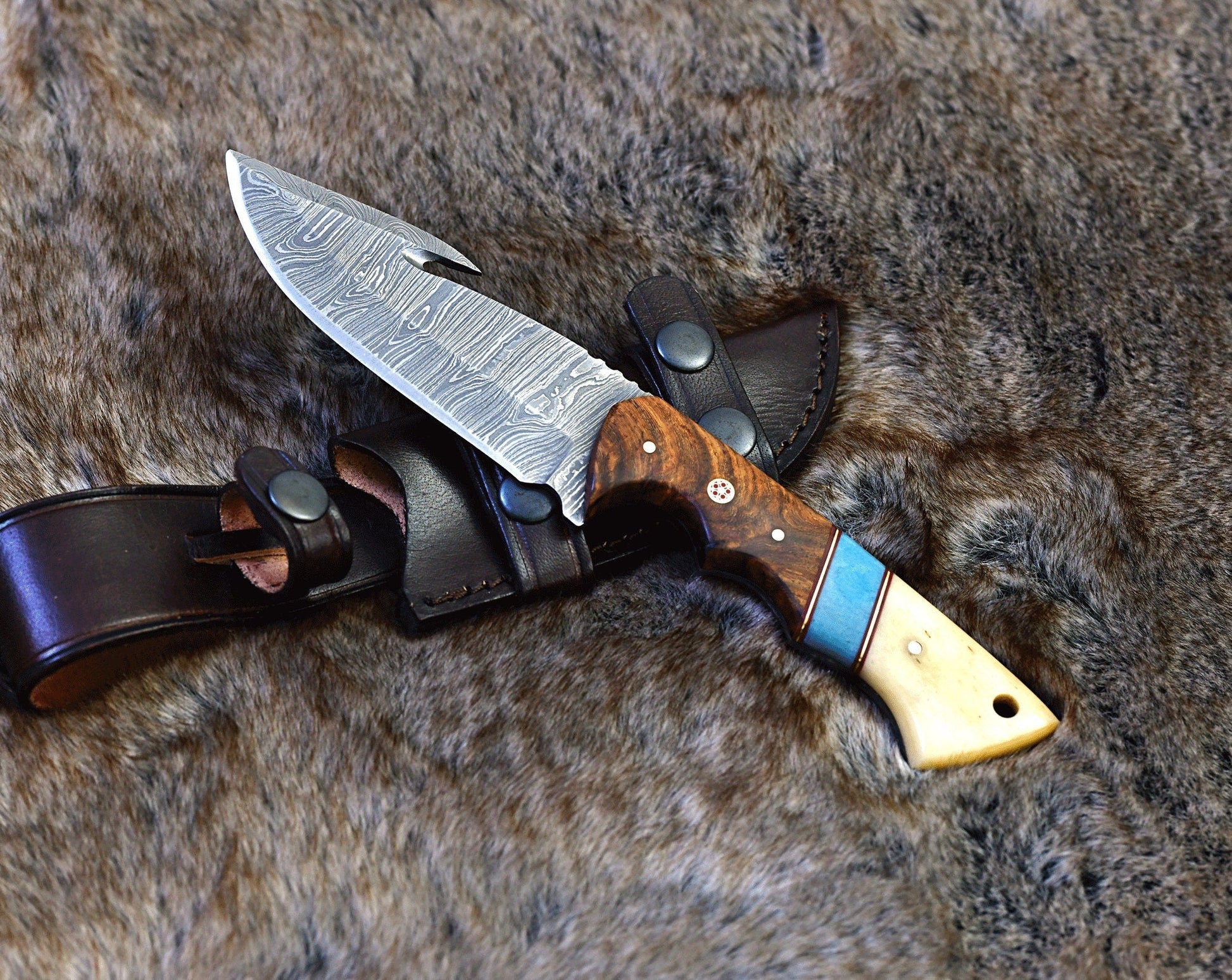 Damascus steel guthook knife with a 10" overall length and rosewood bone handle.