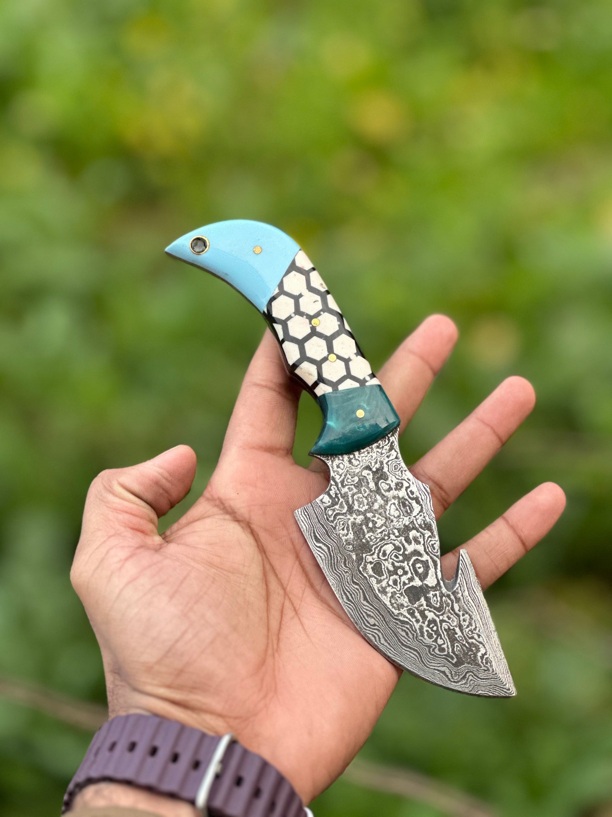 Damascus steel guthook knife with a custom resin handle, perfect for skinning, comes with a leather sheath