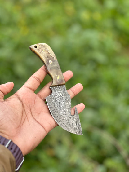 Damascus steel guthook knife with a unique sheep horn handle, paired with a leather sheath.