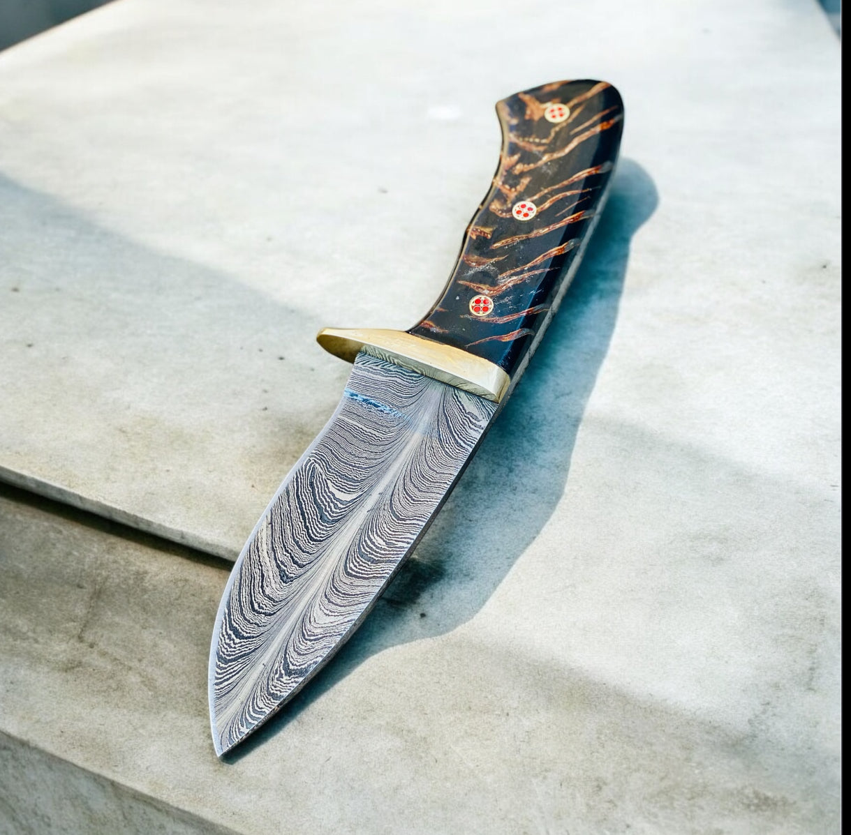 "Damascus steel hunting knife with pain cone handle, brass guard, and leather sheath."

