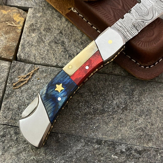 "Damascus steel pocket knife with Texas flag handle and leather sheath"