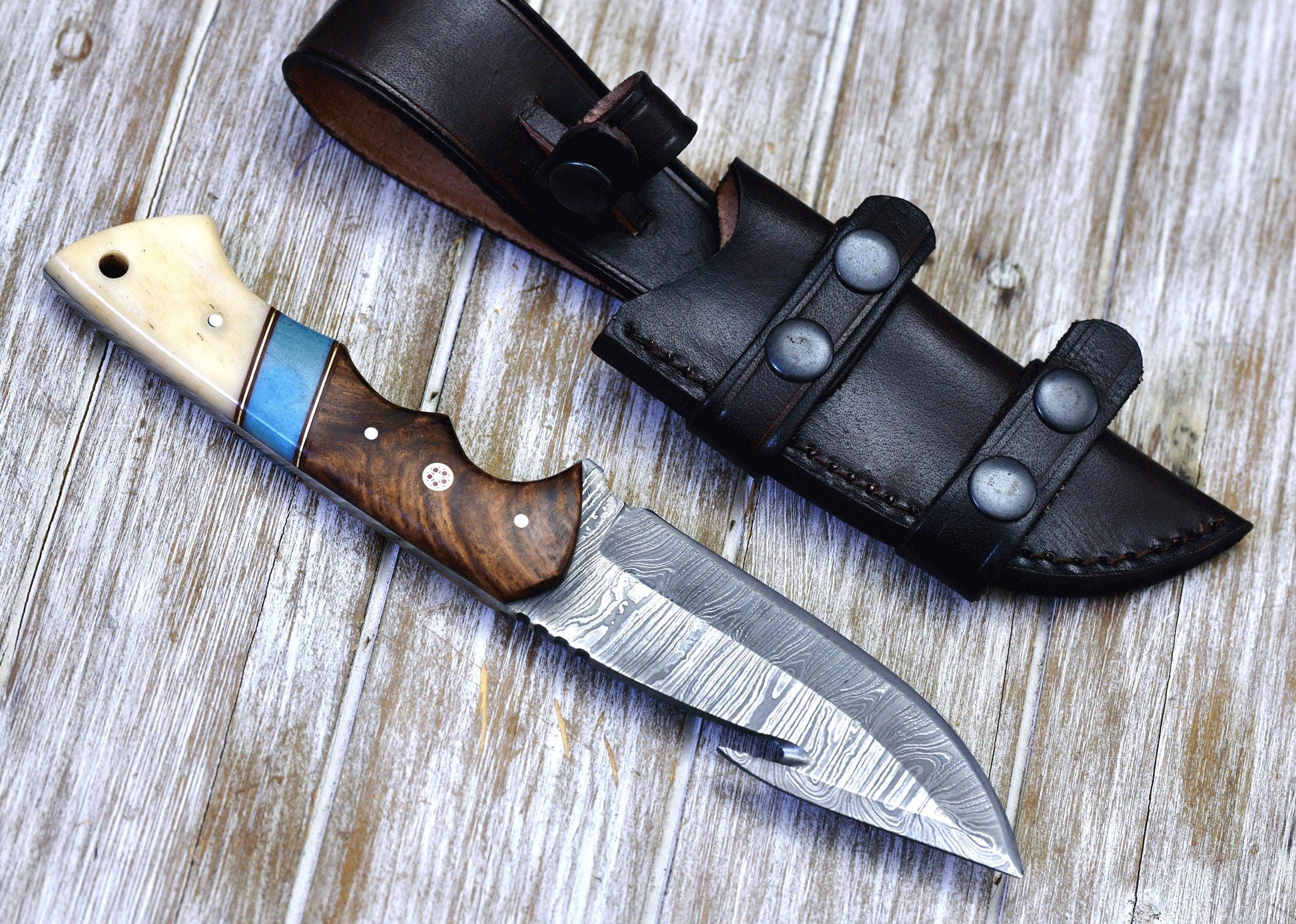 Handcrafted Damascus guthook knife with a rosewood and bone handle, perfect for skinning.