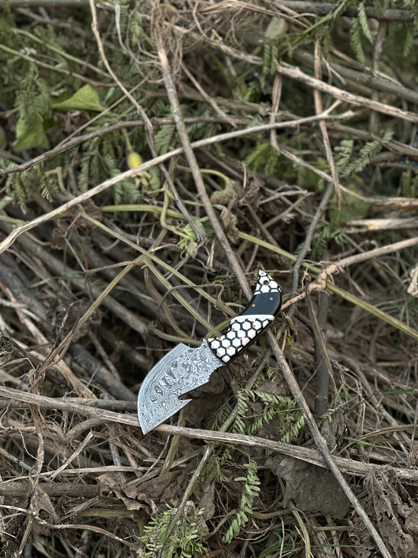 Handcrafted Damascus steel guthook knife with an exclusive resin handle, complete with a leather sheath.