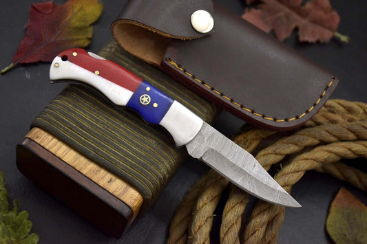 "Handmade Damascus steel pocket knife with Texas flag handle and premium leather sheath"