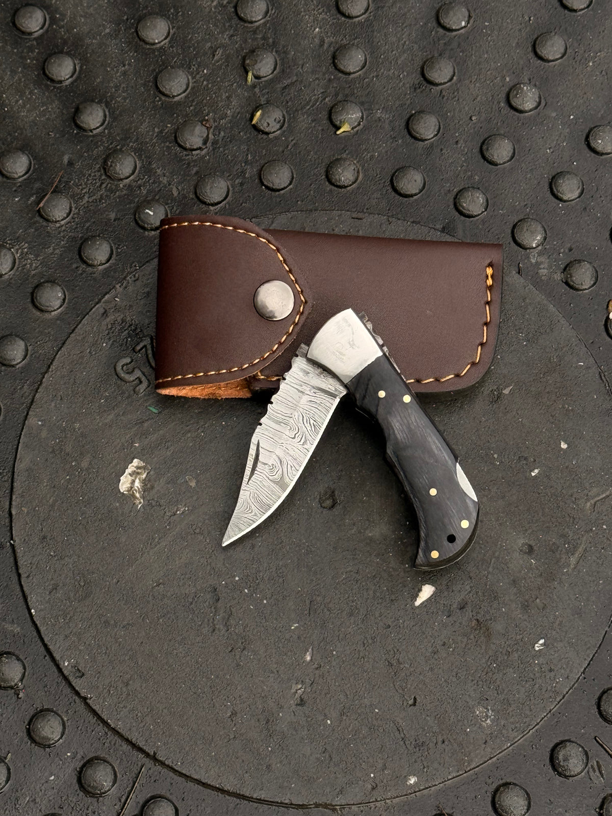 Handmade colored handle folding knife with 6-inch overall length and leather sheath