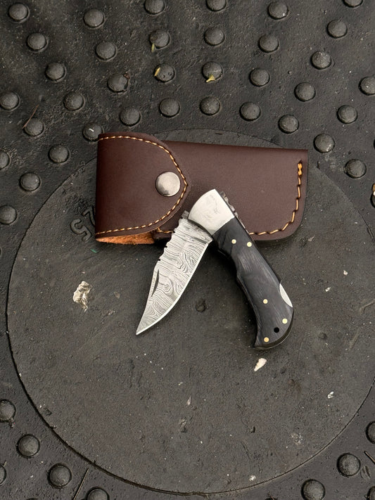 Handmade colored handle folding knife with 6-inch overall length and leather sheath