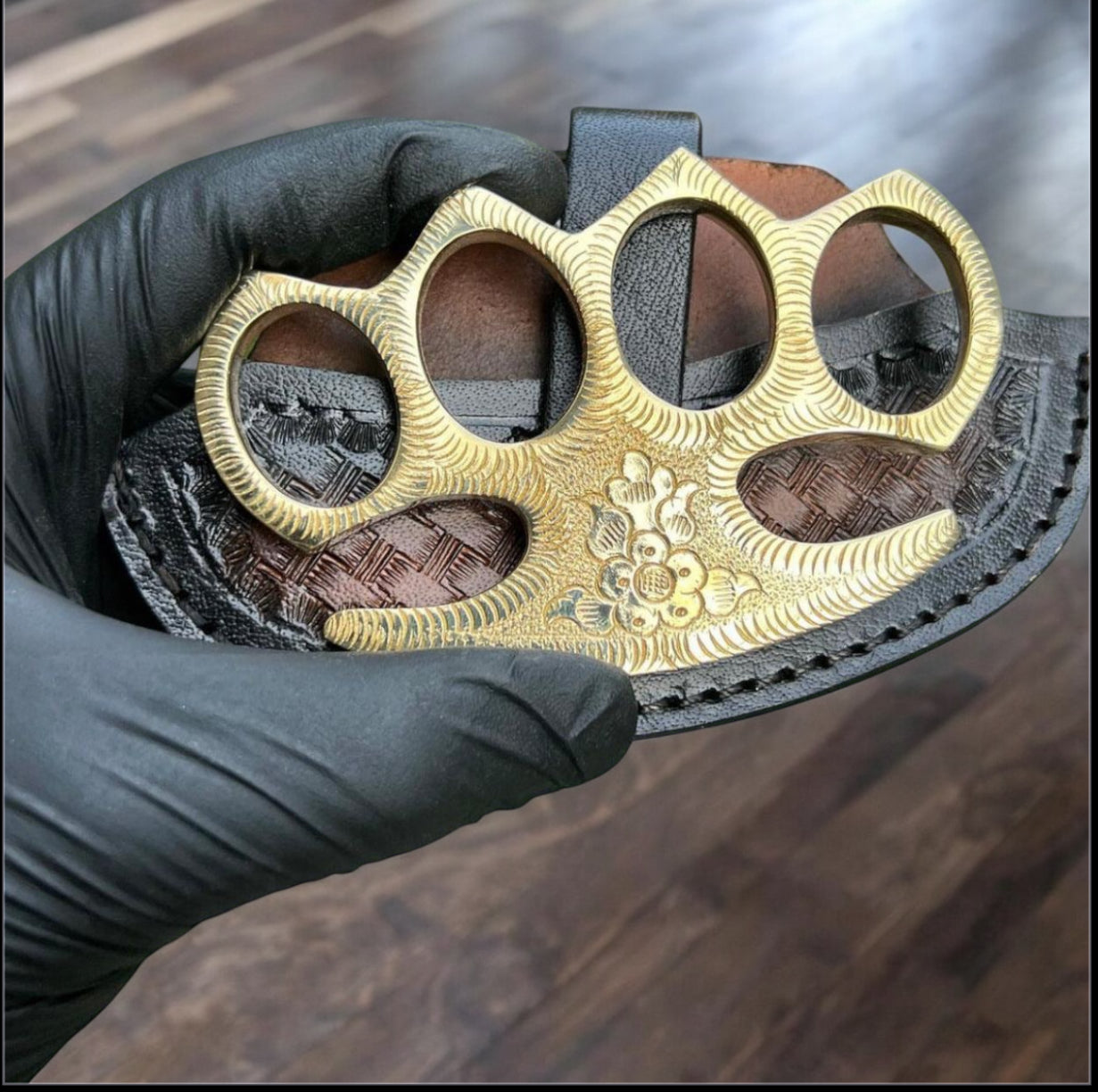 Handmade engraved brass knuckles with intricate designs, crafted from pure brass, displayed alongside a premium belt loop leather case. Perfect for self-defense and style