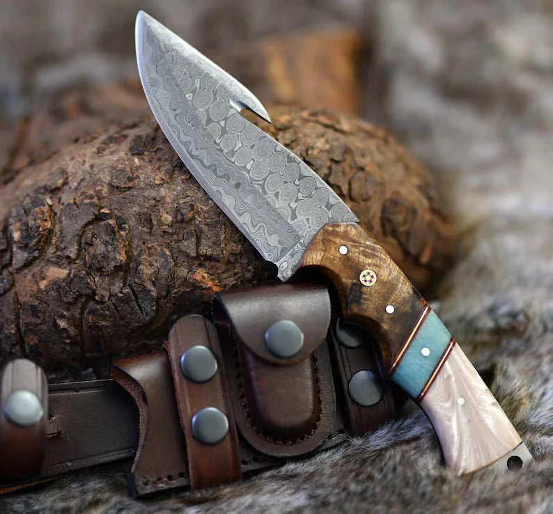 Premium 8.25-inch gut hook skinning hunting knife with Raindrops Damascus steel blade and rosewood epoxy resin handle, with leather sheath.