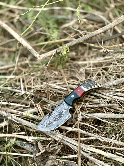 Premium custom handmade Damascus steel guthook knife with a resin handle and leather sheath