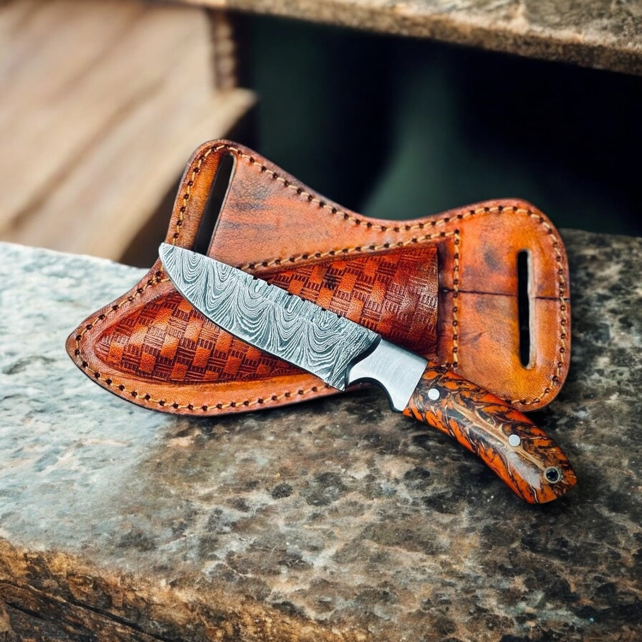 "Rippled Damascus steel blade on cowboy belt knife sheath, showcasing sharp forged patterns"

