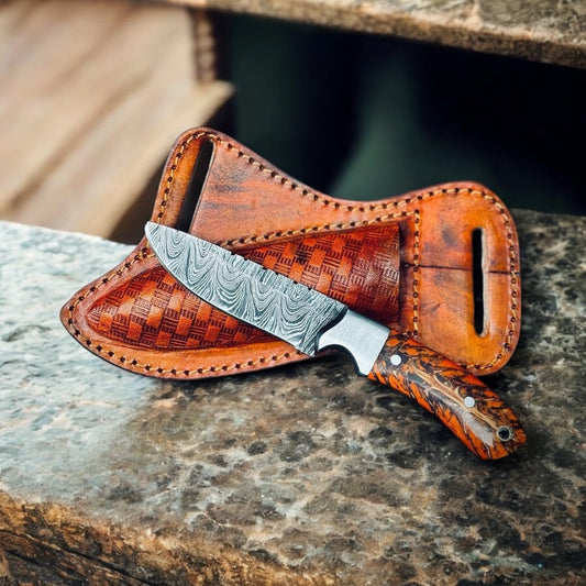 "Rippled Damascus steel blade on cowboy belt knife sheath, showcasing sharp forged patterns"

