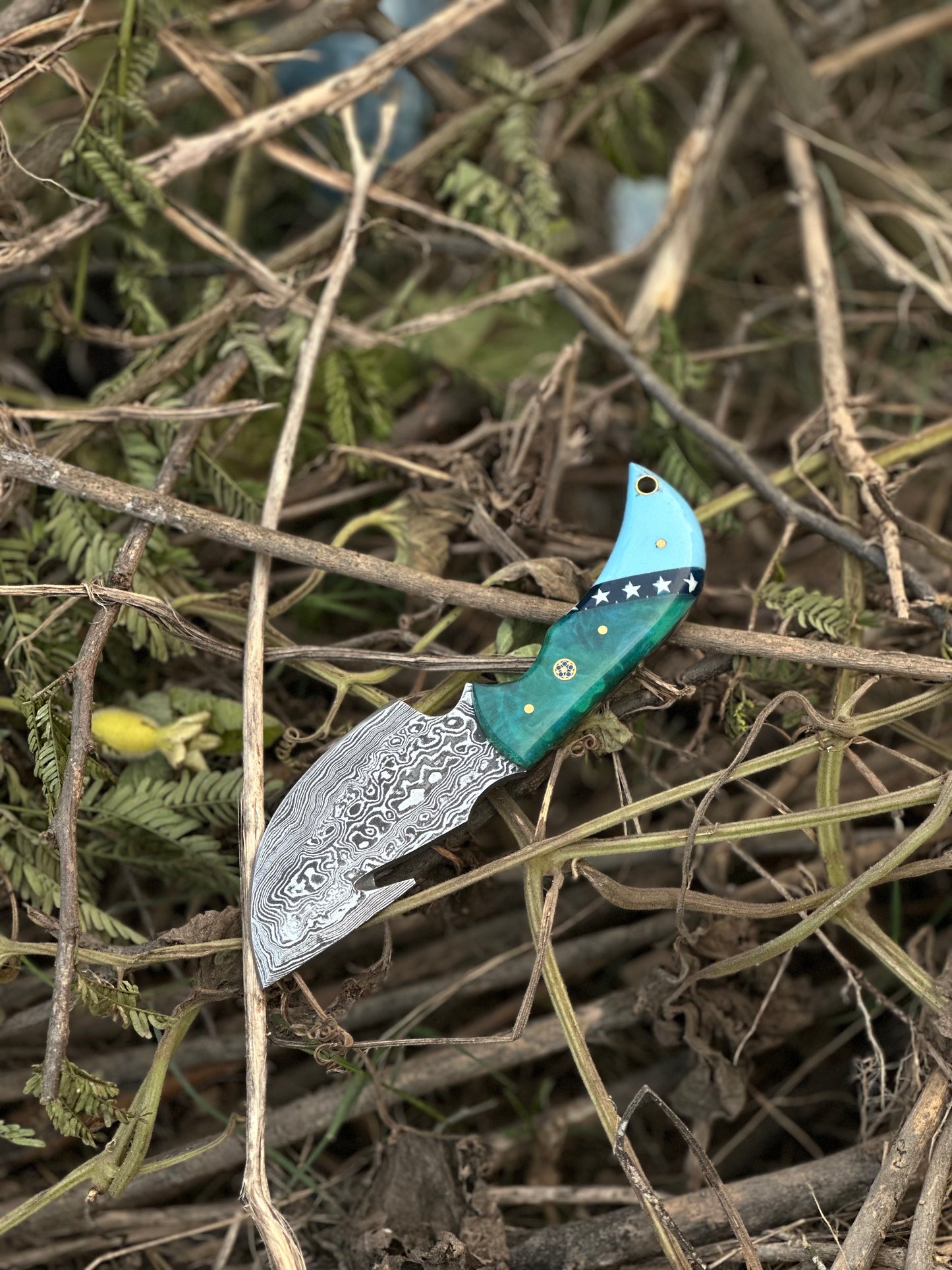 Superior Damascus steel guthook knife with a durable resin handle and custom leather sheath.