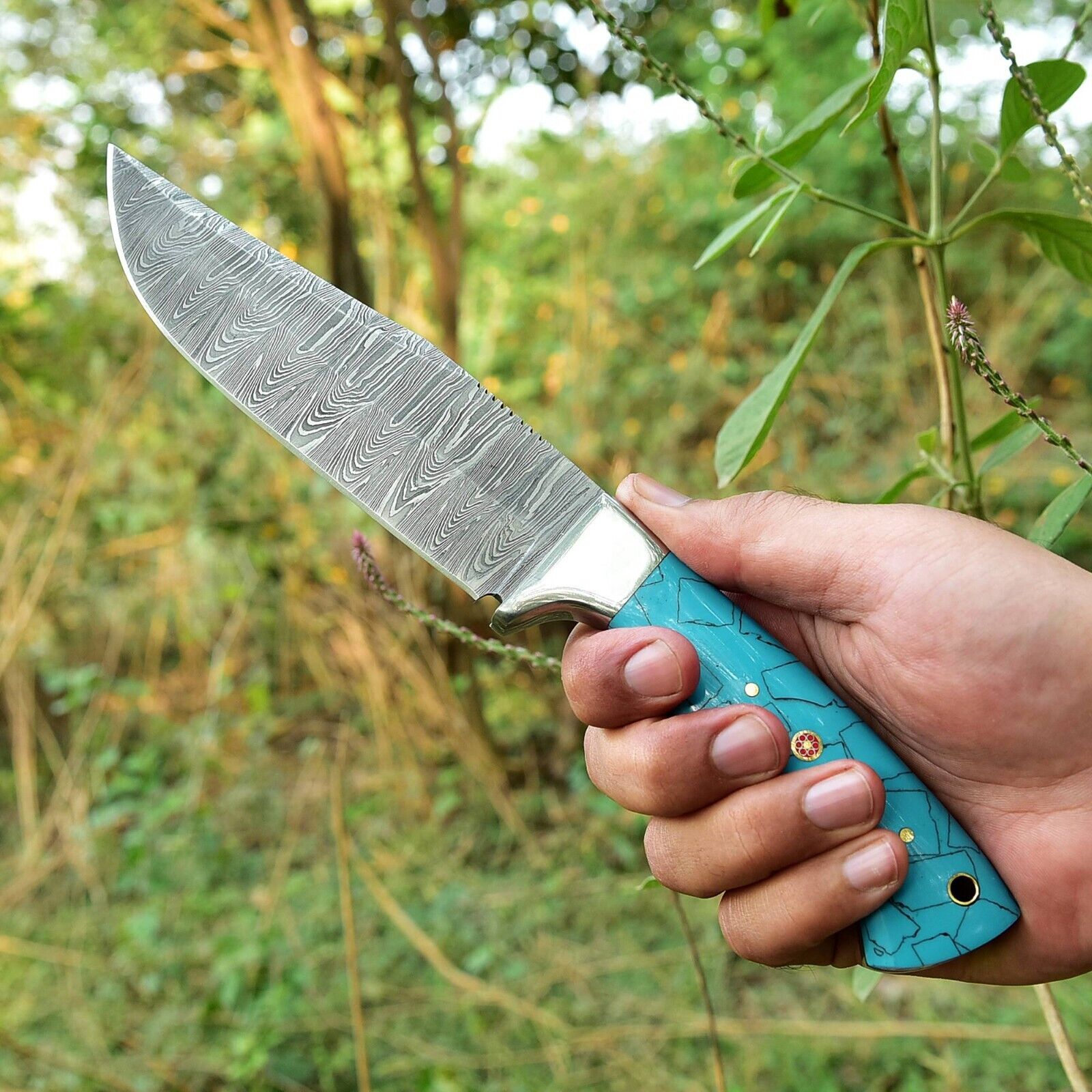 Unique custom skinning knife with Damascus blade, resin handle, and sturdy steel bolster for outdoor precision